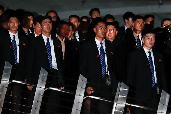 北韓最高領導人金正恩11日晚造訪新加坡魚尾獅公園，身旁護衛形成緊密的人牆，維安滴水不漏。（路透）