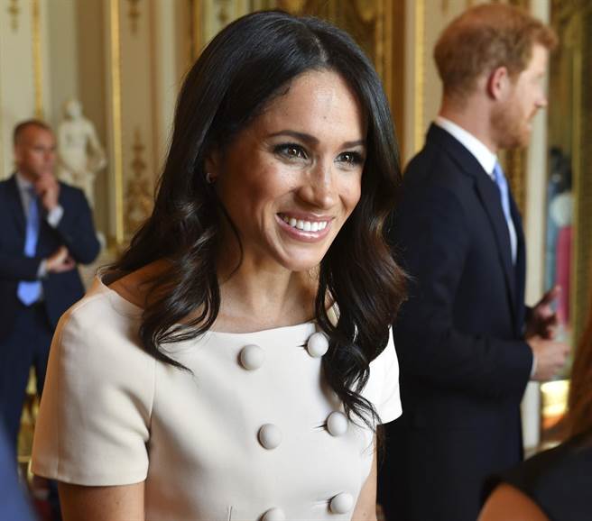 梅根6月26日穿着淡粉红色普拉达（Prada）双排扣套装，与新婚夫婿哈利王子，还有英国女王伊莉莎白二世出席了在伦敦白金汉宫举行的女王青年领袖奖（Queens Young Leaders Awards）颁奖典礼。（美联社）