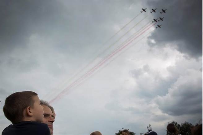 波蘭民眾在遊行現場觀看軍機表演。(圖/路透)