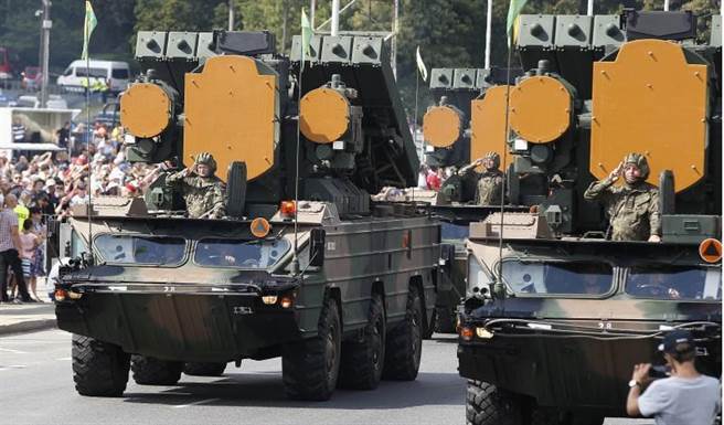 波蘭大型軍用車輛駛過建軍節遊行現場。(圖/美聯社)
