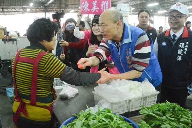 韩国瑜与菜贩热情握手，还不忘告诉对方：「我以前也是卖这些菜，一样的！」（本报系资料照片）