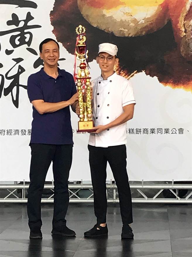 新北市長朱立倫頒發獎杯給蛋黃酥節得獎店家。（陳俊雄攝）