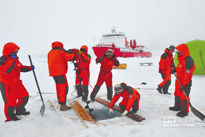 大陸北極科考隊員在海冰上進行科學考察。背景為大陸極地破冰科考船「雪龍號」。（新華社）