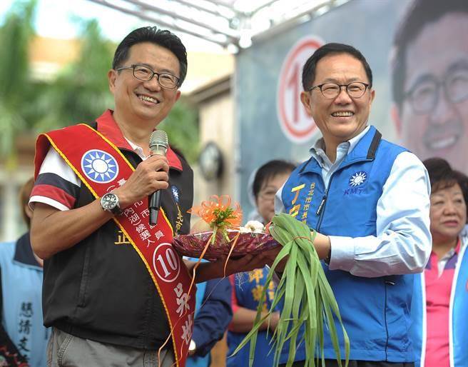 台北市长参选人丁守中（右）20日为国民党台北市议员参选人吴世正（左）的竞选总部开幕典礼站台，并且亲自致赠象徵当选的蒜头。（季志翔摄）