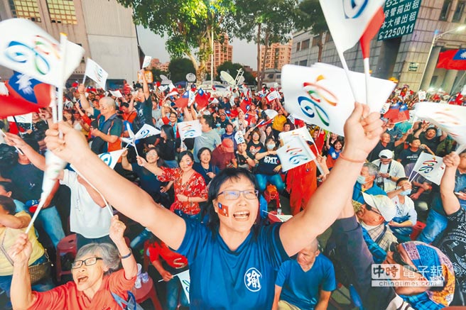 韓國瑜支持者24日聚集在高雄市黨部前關注開票，搖旗吶喊氣氛嗨。（中央社）