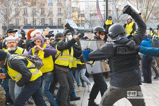 法國巴黎「黃背心」示威活動再次登場，示威者和鎮暴警察也再次爆發衝突。圖為凱旋門附近，鎮暴警察正在驅趕示威群眾。（法新社）

