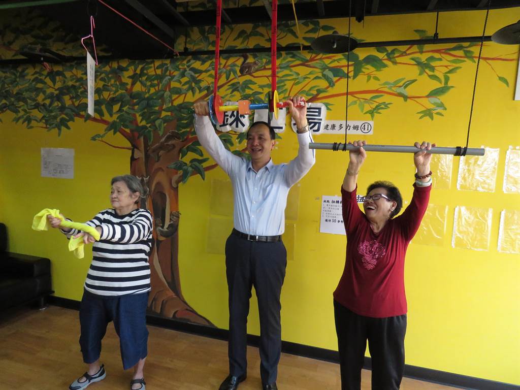 新北市長朱立倫22日上午10時許出席永和錸工場公共托老中心開幕活動，朱立倫（中）和長輩一起做扭轉乾坤運動。（葉書宏攝）