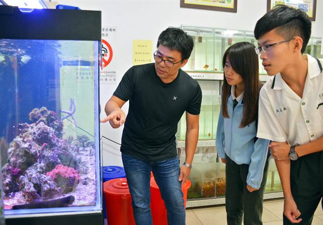 歐武雄（左）將自己對海底生物的喜愛帶進學校，跟著學生一起觀察海底世界。（林和生攝）