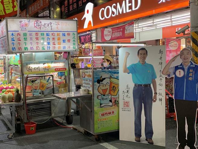 六合夜市木瓜牛奶攤商擺放高市長韓國瑜、前總統馬英九人形立牌，盼吸引遊客目光。（柯宗緯攝）