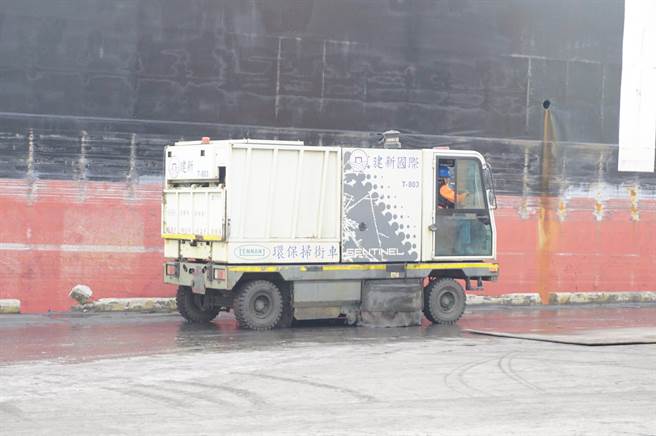建新公司於台中港卸貨碼頭進行銅土卸裝作業，現場配置掃街車來回清理。（王文吉攝）