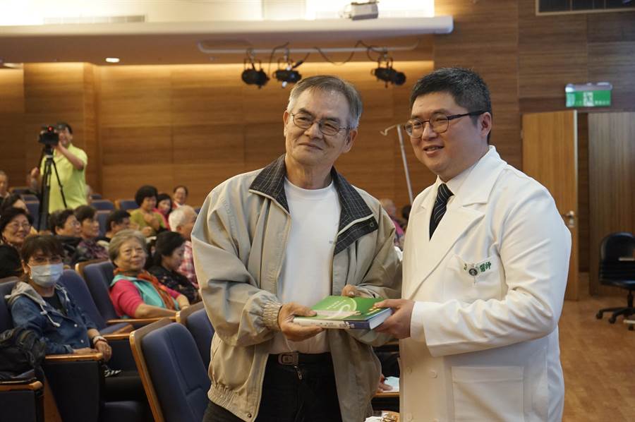 花蓮慈濟醫院骨質疏鬆照護中心主任葉光庭（右）頒發有獎徵答禮品給民眾。（張祈攝）