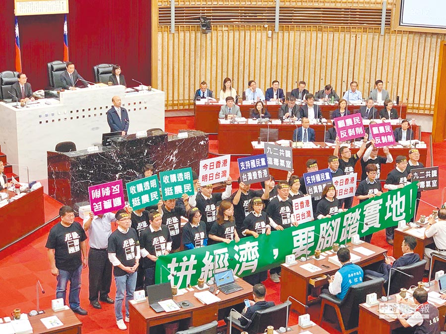 高雄市長韓國瑜1日在議會報告，民進黨團坐在報告台前方拉布條「無聲抗議」。（柯宗緯攝）