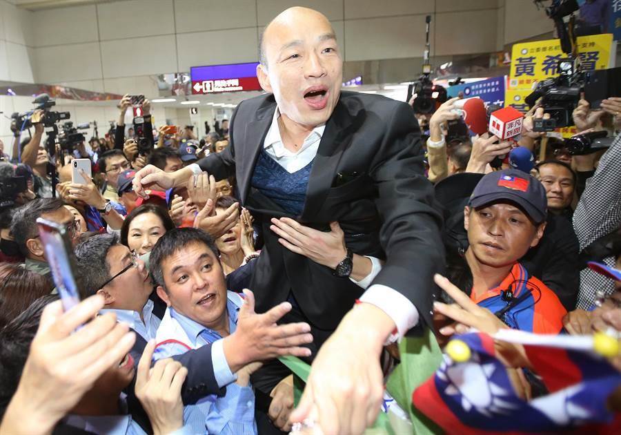 高雄市長韓國瑜（中）18日返抵國門，大批熱情民眾前往機場接機，熱情支持者將韓國瑜高高抬起，接受群眾歡呼。（范揚光攝）