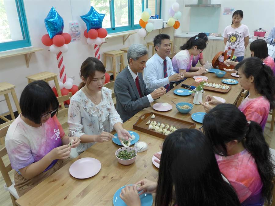 興大校長薛富盛（左三）與學生一起包水餃，慶賀興大女宿舍「誠軒」落成啟用。（林欣儀攝）