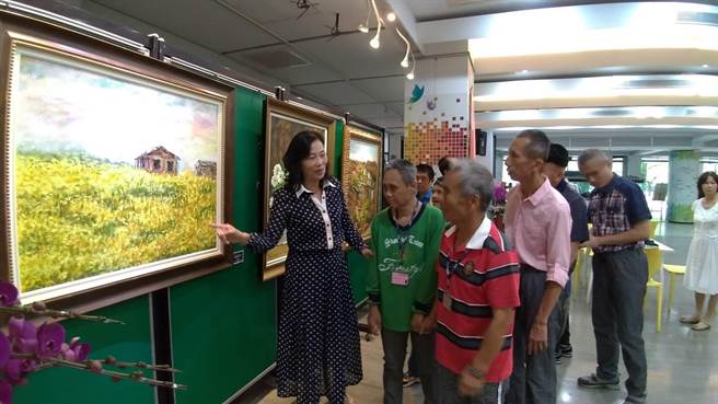 台南教養院職員李淑美閒暇之餘投入油畫創作，個展即日起在民治市政中心展出，2日院生來參觀畫作，替她加油打氣，也感受藝文氣氛。（莊曜聰翻攝）
