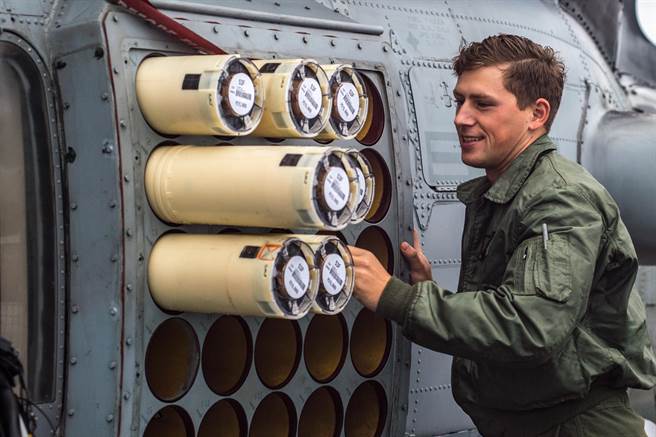 一名美军驱逐舰上的海军航空兵正在为SH-60海鹰反潜直升机装置声纳浮标，这项空投的潜艇侦测器是反潜任务的重要装备。（图／美国海军）