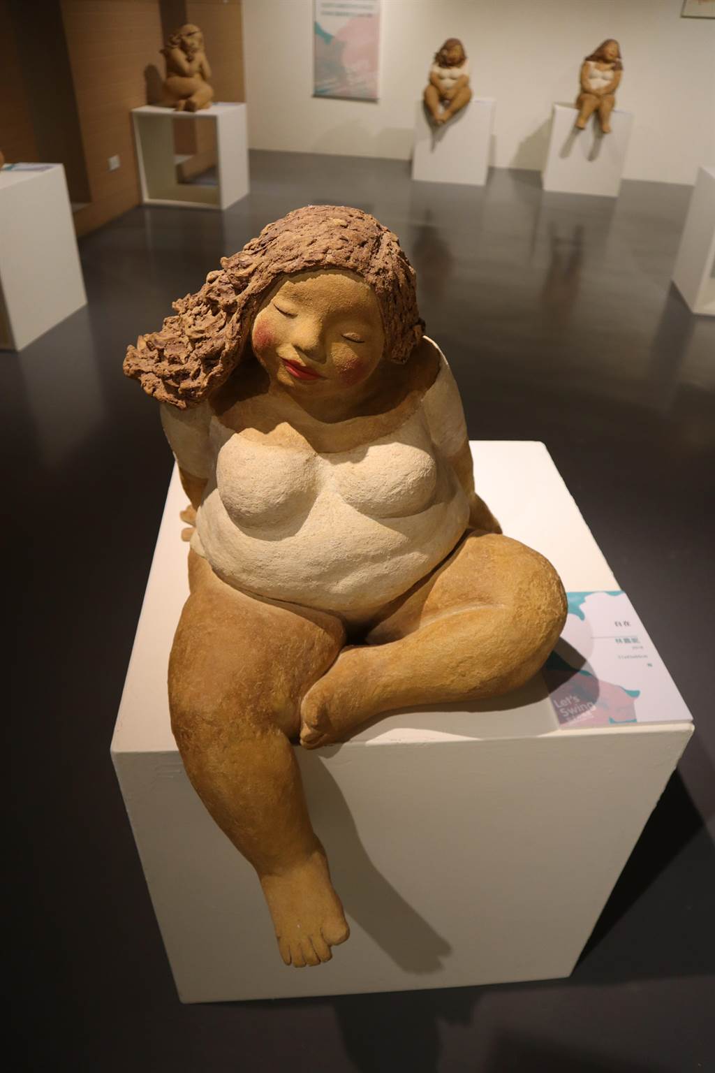 新營文化中心「女子好搖擺：女性主題創作特展」，林嘉妮的陶偶作品，圓潤豐腴的女性或坐或躺，展現各種自信美。（劉秀芬攝）