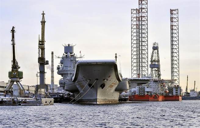 俄罗斯将于2023启动首艘核动力航母研发，排水量预计为7万吨。图为目前俄海军唯一现役柴油动力航母库兹涅佐夫海军上将号，去年在进厂大修时发生意外，至今仍停泊港内待修，预计2021完工。（图／塔斯社）