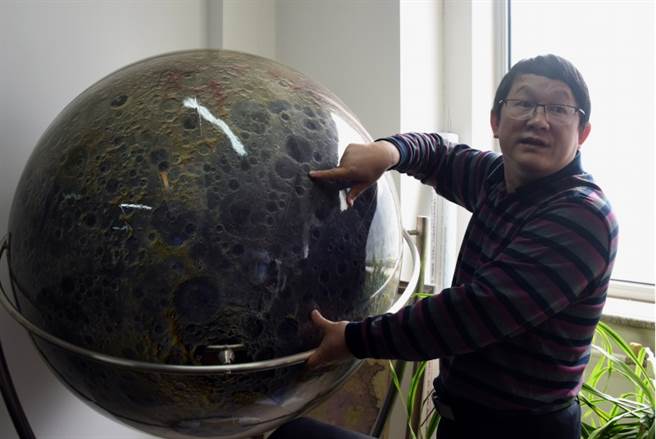 中国科学院国家天文台5月16日说，由李春来领导的研究团队利用嫦娥4号就位光谱探测数据，发现并证明月背南极-艾托肯盆地存在以橄榄石和低钙辉石为主的月球深部物质，这为解答月幔物质组成提供了直接证据。图为论文发表前夕，李春来利用月球仪向媒体介绍嫦娥4号在月背着陆的位置。（中新社）