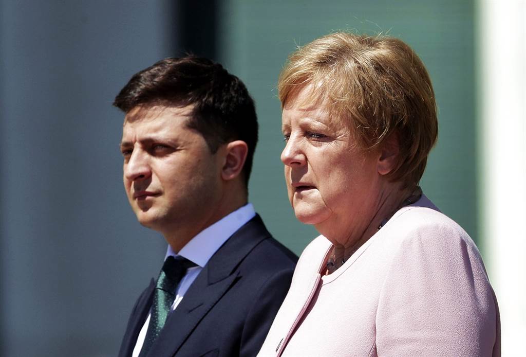 德国总理梅克尔（右）18日在迎接乌克兰新总统泽伦斯基（左）时，身体忍不住不断抽搐，全身颤抖得很厉害，她事后归咎于脱水，不过英国医生认为有可能是一种称为「站立性颤抖」的症状。（图／美联社）(photo:ChinaTimes)