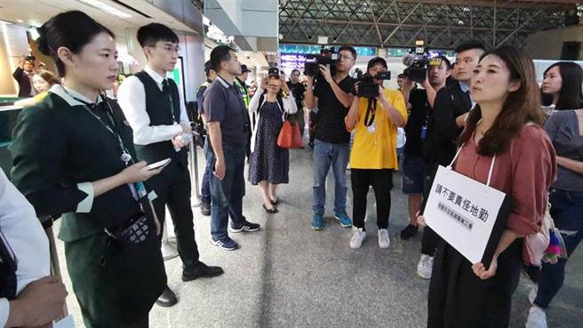 桃空职工副理事长廖以勤(右一)23日率队前往桃园机场，并在脖子上挂「请不要责怪地勤」的牌子慰问地勤人员。（陈麒全摄）