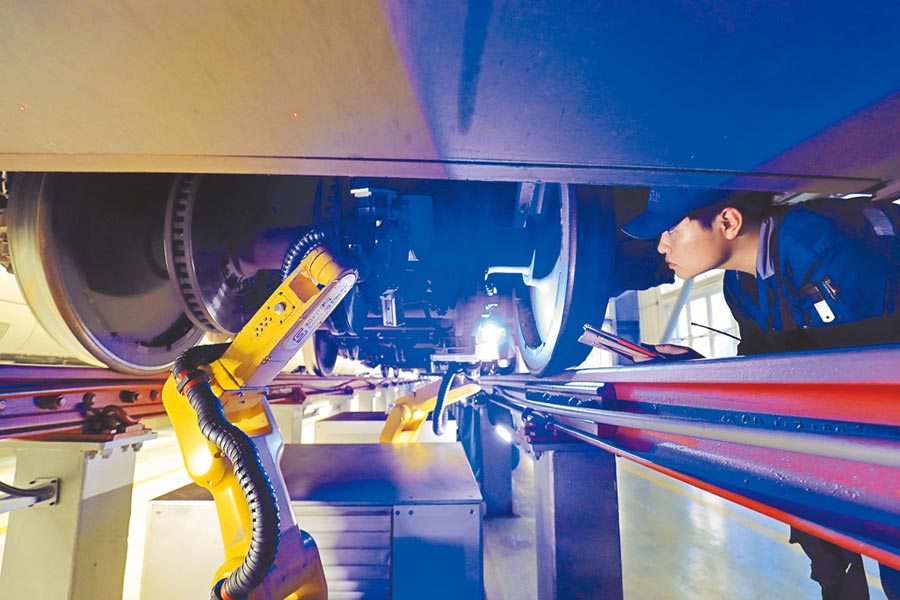6月3日，檢測機器人正在工作人員的監控下進行高鐵車底檢查。（中新社）