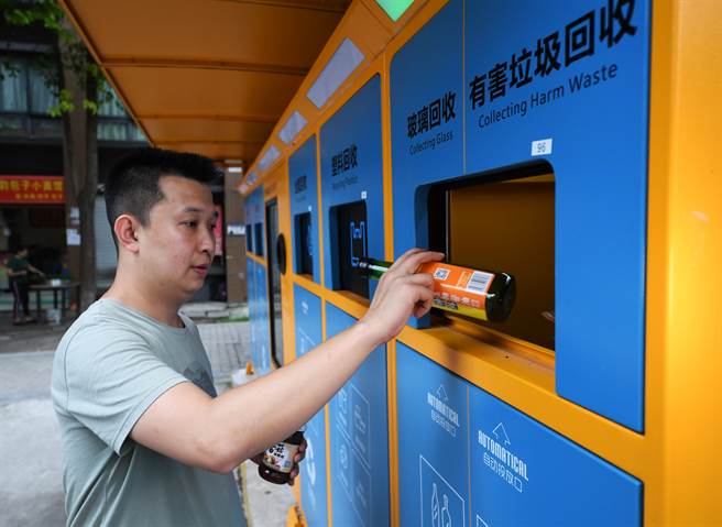 大陆各地推动垃圾分类如火如荼，还用上最新的人工智慧技术。图中重庆居民将废弃的玻璃瓶投入智能垃圾分类回收机。 (图／新华社）