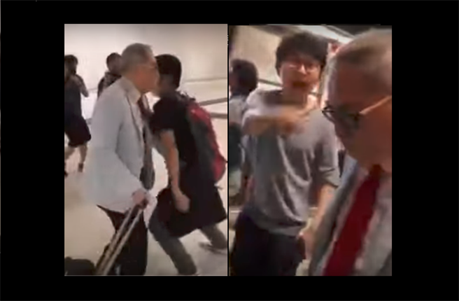 26日在香港機場進行抗議的年輕人圍堵一位老年旅客並高聲辱罵。（圖／網路視頻截圖）