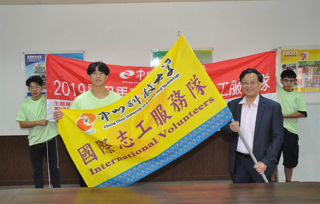 黃思倫校長(前右)授旗給中州國際志工服務隊，由志工隊長巫柏毅(前左)代表接受。（謝瓊雲攝）