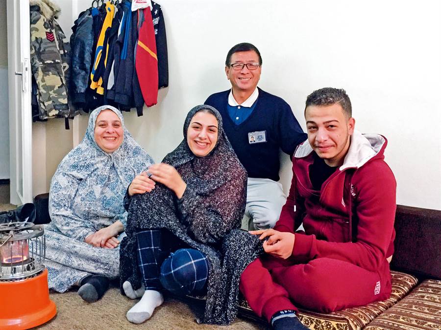 法西雅（左）罹患骨癌，兒子莫罕默德（右）在敘利亞時腳受傷，女兒絲柏（中）也逃到約旦；後為慈濟志工陳得雄。（圖／慈濟基金會提供）