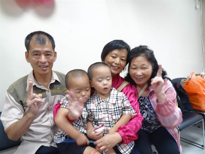 陳振榮夫妻帶著兩個雙胞胎兄弟回到協助他們人工生殖的醫院。（馮惠宜攝）
