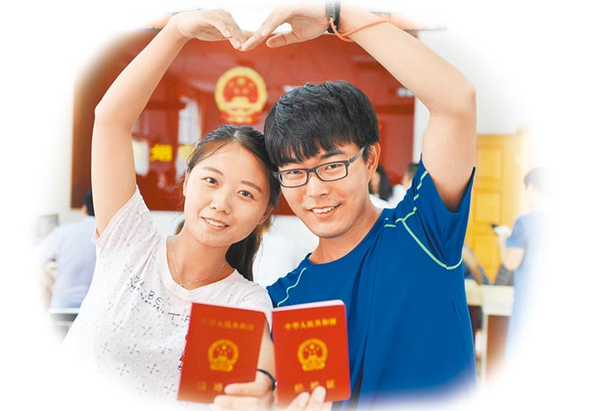 河北石家莊一民政局婚姻登記處，一對新人展示剛領取的結婚證。（中新社資料照片）