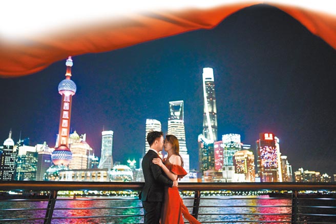 一對青年男女在上海外灘拍攝婚紗照。（新華社資料照片）