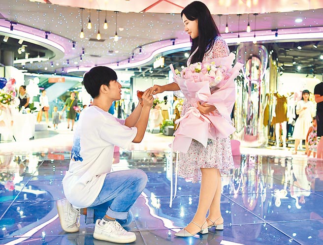 7月21日河北石家莊先天下廣場，男方單膝下跪向女孩求婚。（中新社）