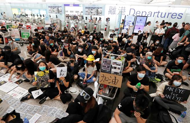 反送中抗議者堵塞香港機場，聚集人數愈來愈多，機管局被迫暫停旅客報到服務。（圖／路透）