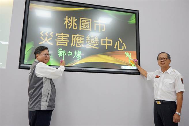 全新的災害應變中心啟用，由市長鄭文燦（左）與消防局長謝呂泉（右）一起主持。（甘嘉雯攝）