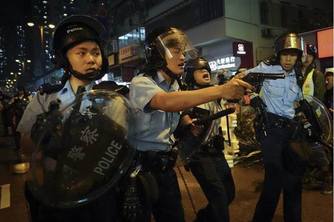 示威者與警察衝突，至少3名警員拔出左輪手槍對向示威者，傳出槍響。(美聯社)