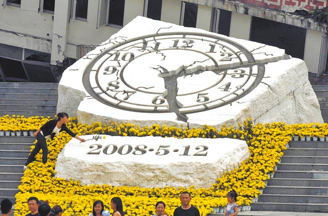 2011年5月12日，汶川特大地震三周年紀念日，一位民眾向汶川縣映秀鎮地震紀念雕塑獻花。 （新華社）