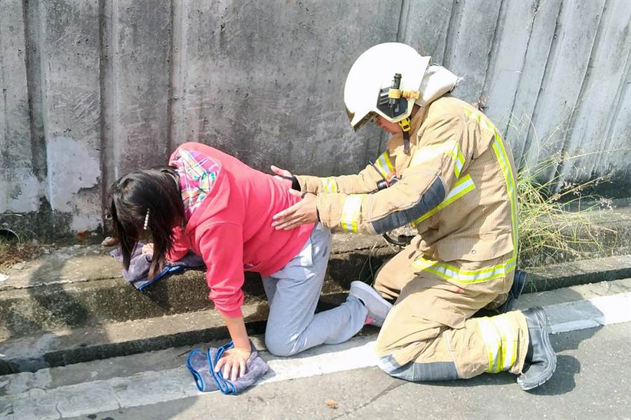 消防人員協助右腳卡在水溝的婦人脫困。（翻攝畫面／洪榮志台南傳真）