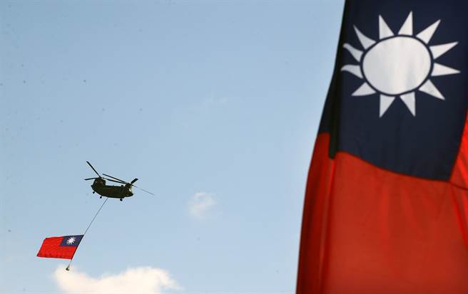 國軍CH-47D直升機，繫一面超大國旗，飛越台北市上空。(圖/范揚光攝)