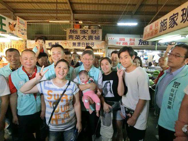 台北市長柯文哲（中）13日到台中市的黃昏市場，為第五選區立委參選人謝文卿拉票，看到小朋友親切的抱起來合照。（盧金足攝）
