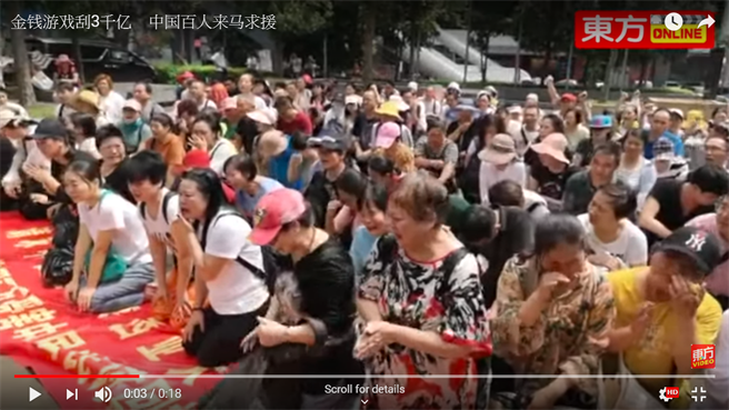 大批投资诈骗的大陆受害者群集中国驻马国领事馆前下跪求情，要求马国当局介入处理。（图／东方日报Youtube截图）