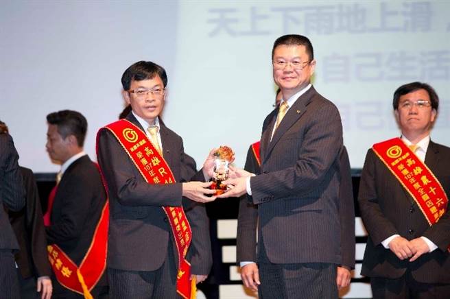 郑曜德店东(图左)代表高雄R14文信加盟店，领取2018年全过业绩杰出奖。图/永庆不动产提供