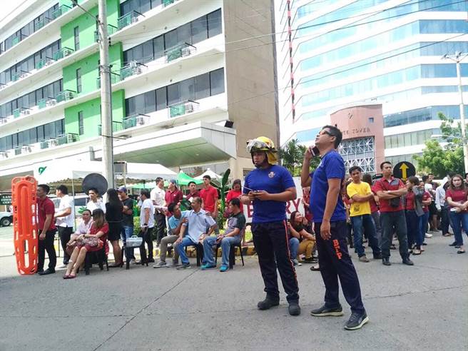 今（29）日上午菲律宾南部民答那峨岛达纳卯（Davao）西南方58公里处发生规模6.7强震。纳卯（Davao）市上班族感受到强震后惊恐跑到建筑外等候。（图／美联社）