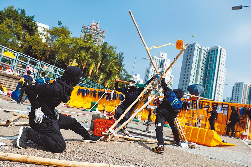香港浸會大學示威學生使用簡易彈弓發射網球穿越路障。（路透）