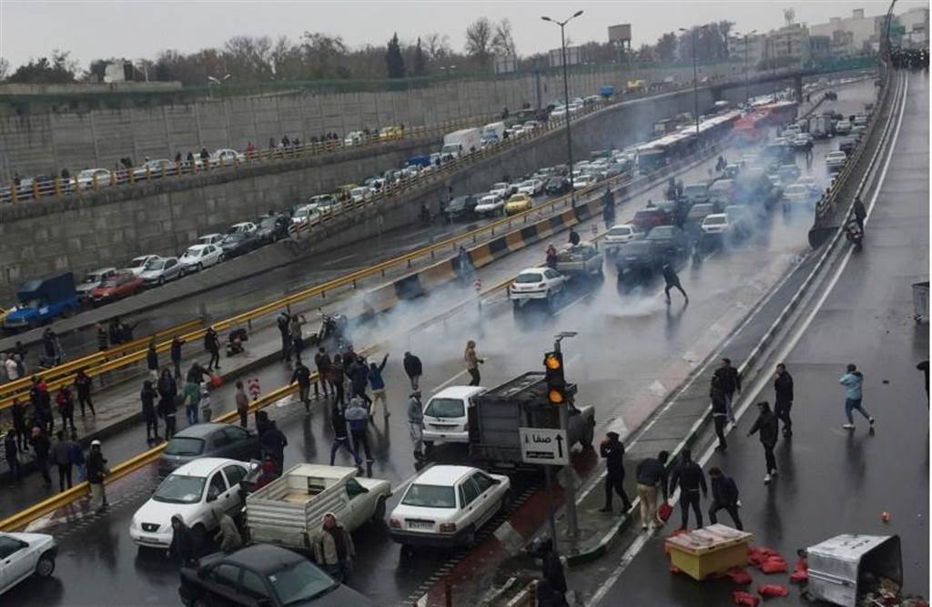 伊朗民眾16日在德黑蘭一條公路上示威，抗議汽油價格飆升。（路透）
