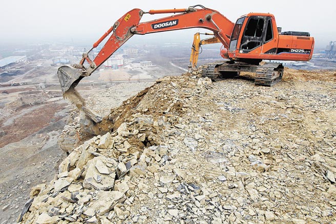 大陸水泥嚴重缺貨。圖為山東棗莊施工人員使用機械清理廢棄的採石坑。（新華社資料照片）