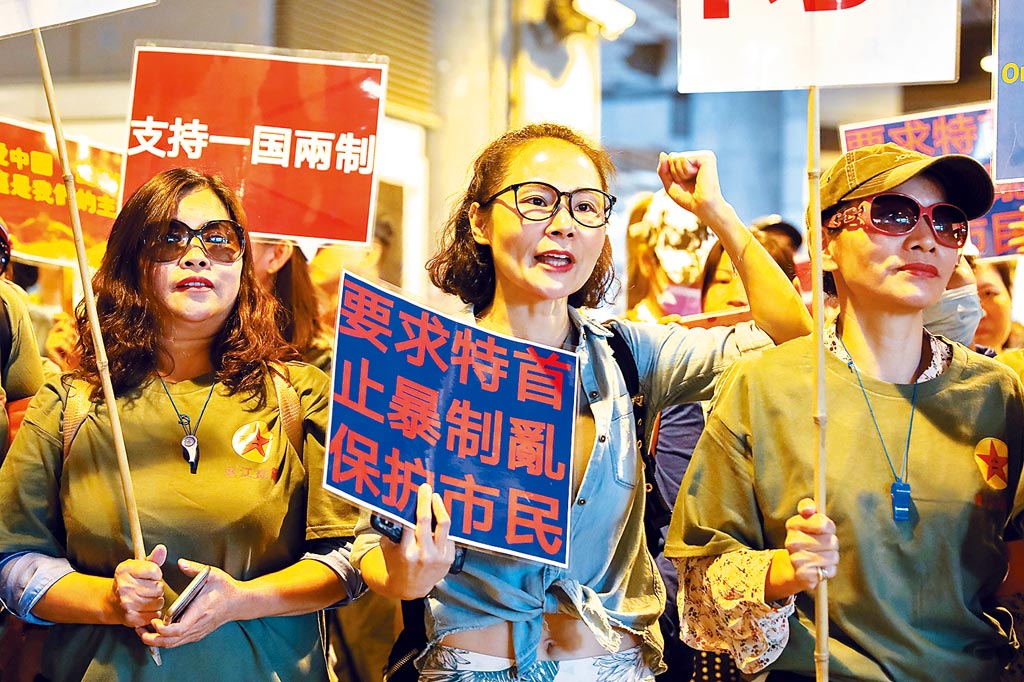 11月14日，逾百香港市民在元朗舉行集會，高舉「支持一國兩制」等標語。（中新社）