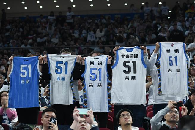 北京球迷高舉剛過世的吉喆球衣，來悼念這名前北京首鋼球員。(新華社)