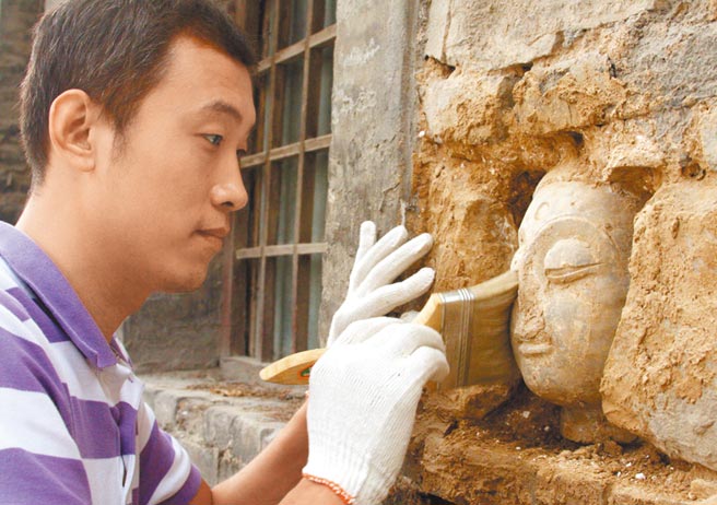 河北响堂山石窟，文物工作者在清理佛像。（中新社资料照片）